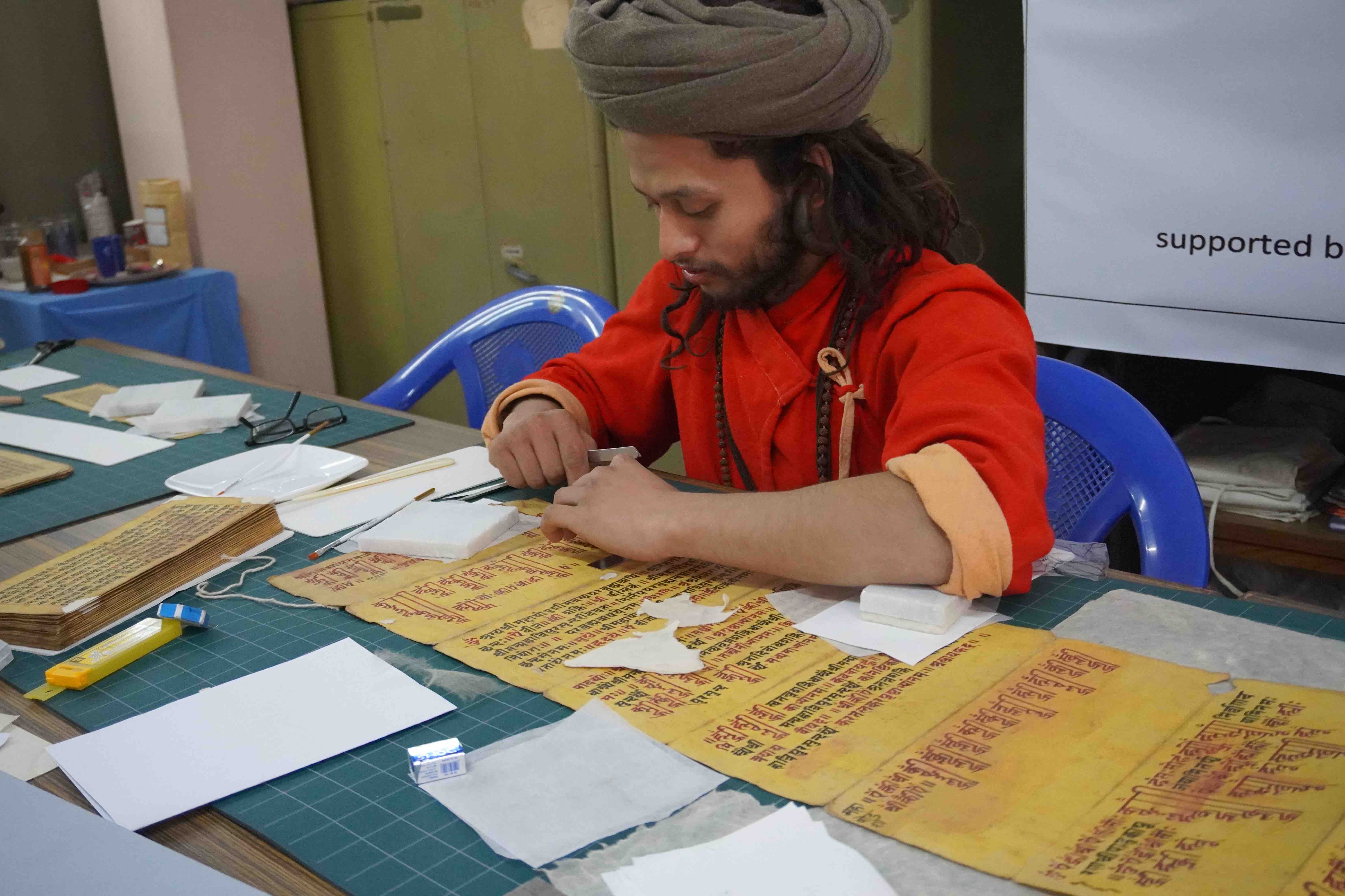 Y. Brahmanath, of the Yogi Naraharinath Memorial Library and Museum, repairing a manuscript during a workshop at the Āśā Archives, Kathmandu